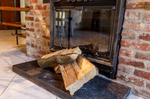 a piece of wood sitting in front of a fireplace at Le verger de La Haze in Esneux