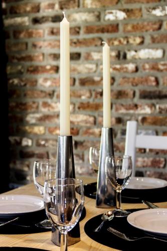 a table with two candles and wine glasses on it at Le verger de La Haze in Esneux