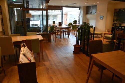 a restaurant with wooden floors and tables and chairs at Business Inn Norte 2 in Sapporo