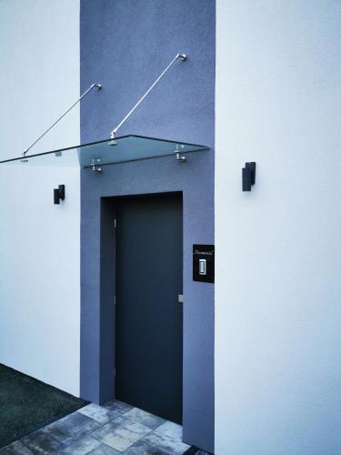 a blue wall with a door in a room at Przystań Dobrej Energii, domki całoroczne z gorącą balią z hydromasażem in Kłodzko