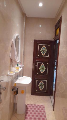 a bathroom with a sink and a wooden door at story house salah in Rabat