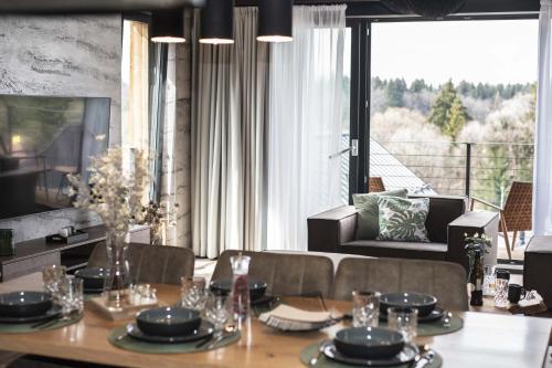 a dining room with a table and a large window at Wellness chalet Vénus in Liptovský Mikuláš
