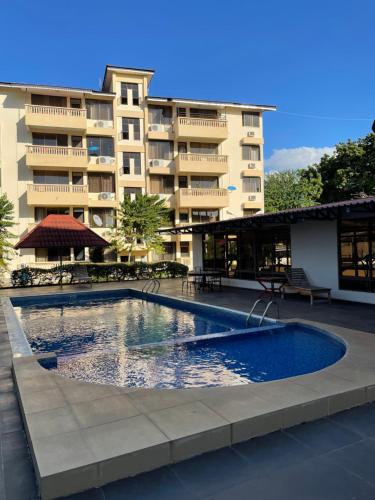 a swimming pool in front of a building at 3BR with pool & gym Apartment by MAS in Dar es Salaam