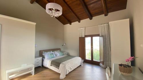 1 dormitorio con cama, ventana y lámpara de araña en Tenuta Belvedere Cilento, en Montecorice