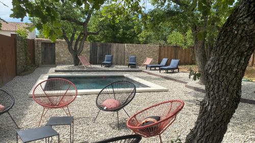 a yard with chairs and a pool and a tree at Gite Couleur Terre à 10MN de Gordes in Croagnes