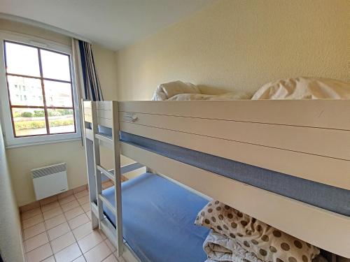 a bunk bed in a small room with a window at Résidence 1 située dans un Magnifique Village Vacances Familiale in Talmont