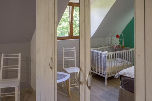 a childs room with a crib and a room with a ladder at Mountain inn in Žabljak