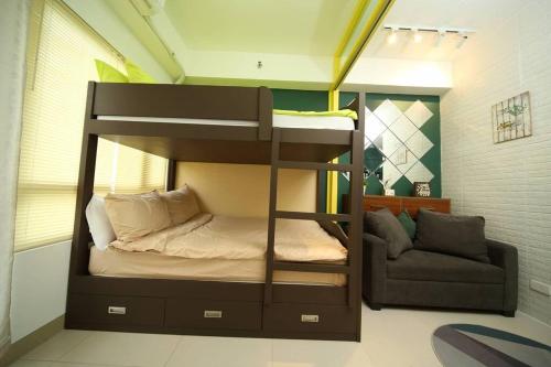 a bunk bed in a room with a couch at A2J Luxury 1BR Tagaytay Suite Near Skyranch, Malls in Tagaytay
