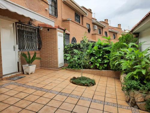 un patio con plantas y un edificio de ladrillo en Habitacion cerca del Aeropuerto, en Coslada