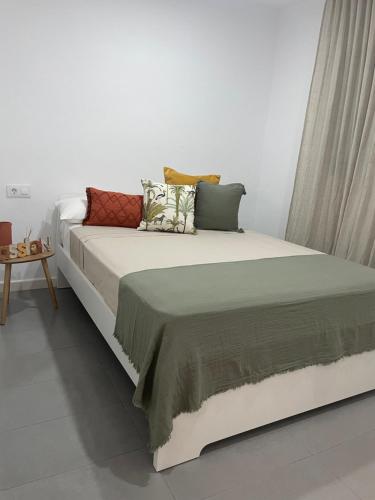 ein großes Bett mit Kissen darauf in einem Zimmer in der Unterkunft Marismas Sol Barbate in Barbate