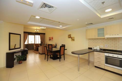 a kitchen and living room with a table and chairs at Ivory Grand Hotel Apartments in Dubai