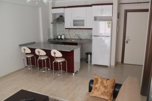 a kitchen with three bar stools and a counter top at Almasa Suite Aparts in Termal