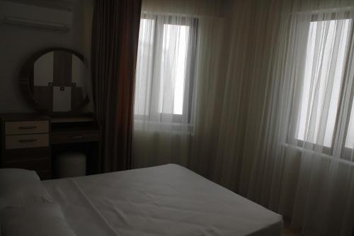 a bedroom with a bed and a mirror and curtains at Almasa Suite Aparts in Termal