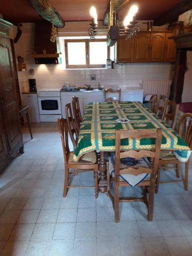 une cuisine avec une table et une nappe verte. dans l'établissement Gite Rural, à Eygurande
