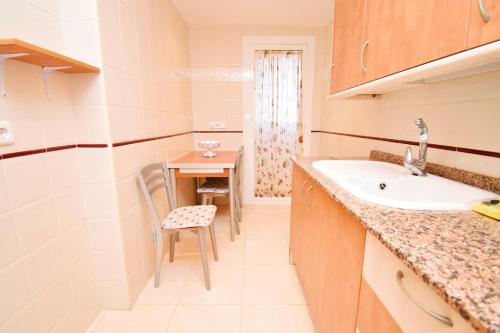 a small kitchen with a sink and a table at Expoholidays-Brisas Almerimar in Almerimar