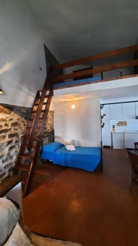 a bedroom with a blue bed and a staircase at La Casetta in Fivizzano