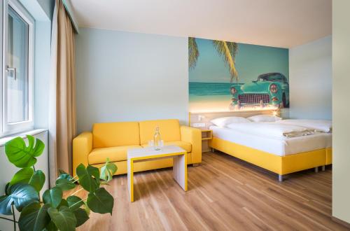 a bedroom with two beds and a couch and a table at Hi5-Hotel Seiersberg in Windorf