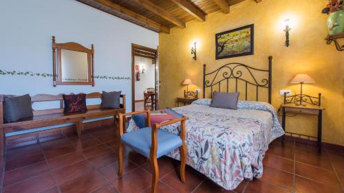 a bedroom with a bed and a table and a mirror at Los Laureles Casa Rural in Urda