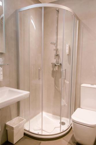 a shower stall in a bathroom with a toilet at Friesen Hotel in Jever