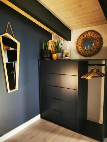 a room with a black cabinet and a mirror at Przystań Dobrej Energii, domki całoroczne z gorącą balią z hydromasażem in Kłodzko