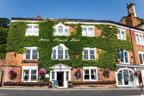 un bâtiment en briques rouges recouvert de lierre vert dans l'établissement Mount Pleasant Hotel, à Great Malvern