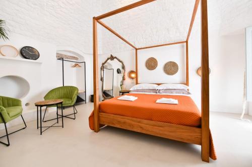 a bedroom with a canopy bed and a table and chairs at Corte Giotto Exclusive House in Carovigno