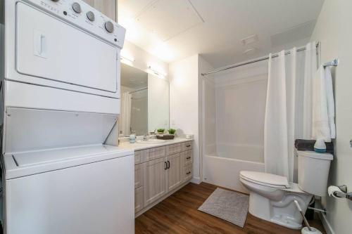 a white bathroom with a toilet and a sink at Spacious 2bedroom FREE parking king bed close to DT in Edmonton