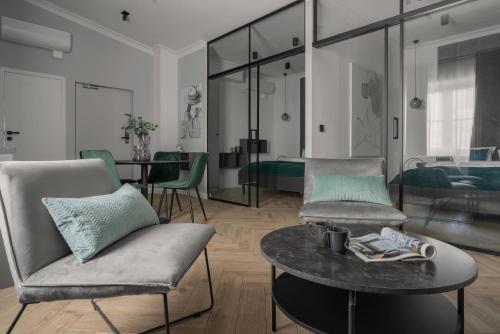 a living room with two chairs and a table at APARTIO ROOMS Katowice in Katowice