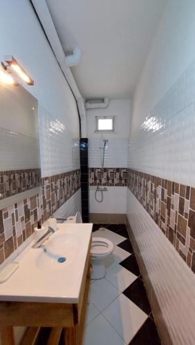 a bathroom with a sink and a toilet at Jozene House in Ngaparou