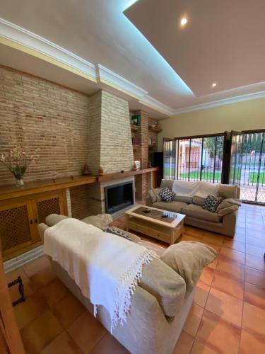 Una sala de estar con un sofá y una chimenea. en Villa Las Viñas, en Ronda