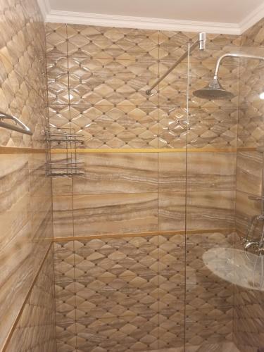 ducha con suelo de madera y cabina de ducha de cristal en AMARA-BOUTIQUE & DESIGN - Студио, en Ravda