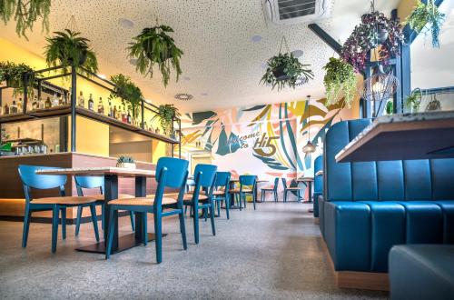 a dining room with blue chairs and a bar at Hi5-Hotel Seiersberg in Windorf