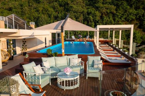 a patio with a pool and chairs and a table at Vujanovic Apartments in Sveti Stefan