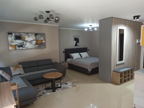 uma sala de estar com um sofá e uma cama em AMARA-BOUTIQUE & DESIGN - Студио em Ravda