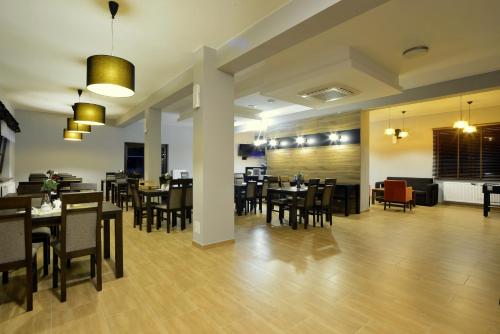 une grande salle à manger avec des tables et des chaises dans l'établissement Villa Asturia, à Rymanów-Zdrój