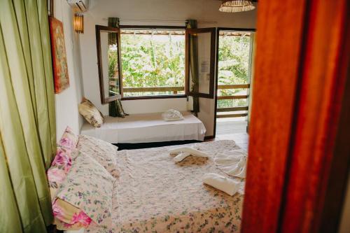 1 dormitorio con 2 camas y ventana en Pousada Arraial Lua Crescente, en Arraial d'Ajuda