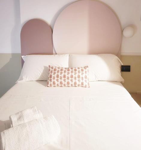 un letto bianco con un cuscino sopra di TUTTOTONDO a Pescara