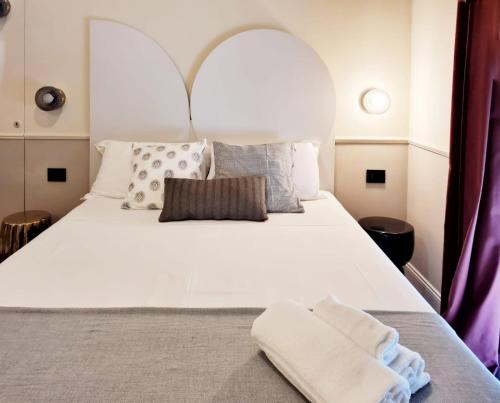 una camera da letto con un grande letto bianco con cuscini di TUTTOTONDO a Pescara
