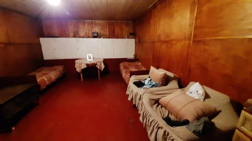 a room with two beds and a table in it at XOSTEL GOCHA in Mestia