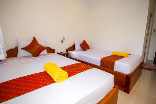 a room with three beds with red and white at Blossoming Romduol Boutique in Siem Reap