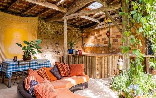 een woonkamer met een bank en een tafel bij La Maison Magique in Saint-Chamassy