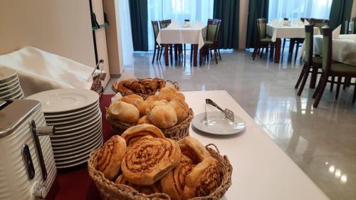 a table with two baskets of bread on a table at Hotel Küküllő - Târnava in Odorheiu Secuiesc