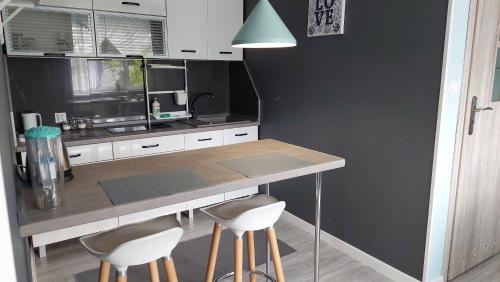 a kitchen with a counter and stools in it at POKOJE GOŚCINNE -MARIA- in Ostrowo