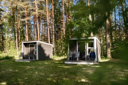 a couple of chairs in a shed in the woods at UKI Puhkeküla in Ranna