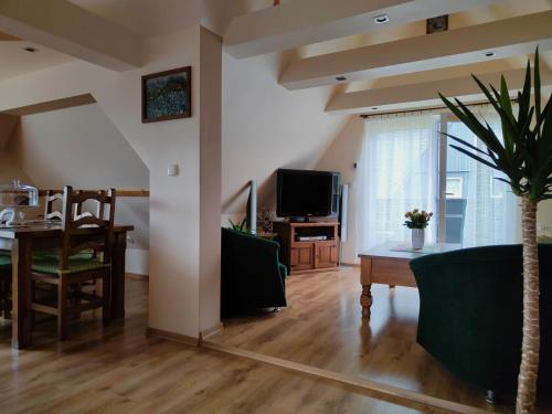 a living room with a table and a tv at Apartament Złap Oddech in Zakopane