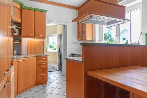 a kitchen with wooden cabinets and a wooden table at Exquisite Shared Villa - Your Private Room in this Beautiful Home in Vienna