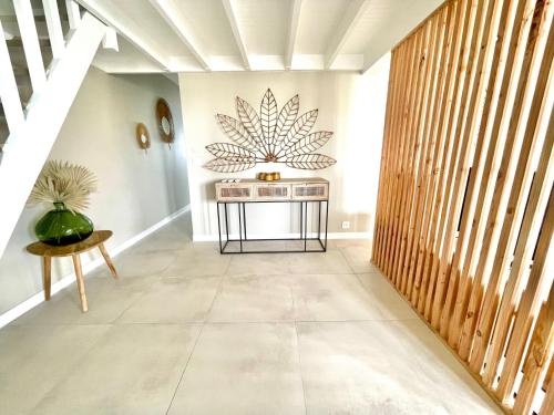 a hallway with a table and a plant on the wall at Le "61" MARINA ROOFTOP 2CH 2SDB TERRASSE MARINA in Baimbridge