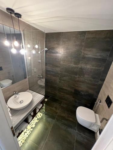 a bathroom with a sink and a toilet at Kanes Boutique Hotel in Sarandë