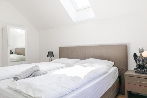 a bedroom with a large bed with white sheets at Exquisite Shared Villa - Your Private Room in this Beautiful Home in Vienna