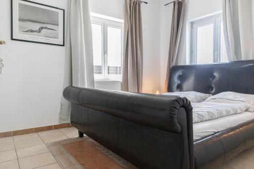 a black leather couch in a room with windows at Exquisite Shared Villa - Your Private Room in this Beautiful Home in Vienna